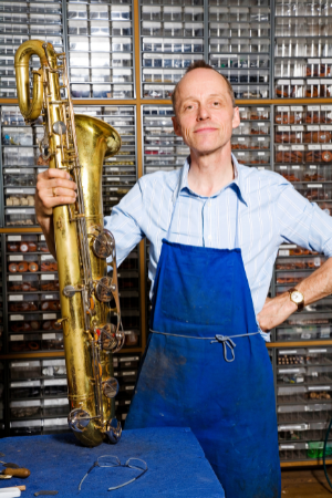 Der Fachmann repariert sowohl Bass-Saxophone, als auch das Sopran Saxophon